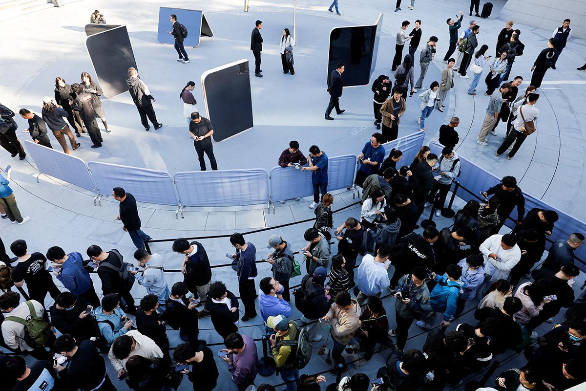 Люди стоят в очереди у магазина Apple Jing'an в Шанхае в связи с началом продаж нового складного смартфона Apple — iPhone Duo — по всему Китаю
