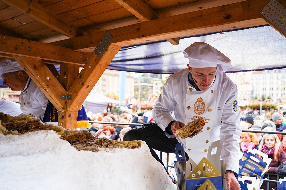 Пекари вручную раскатывают и формуют тесто для штоллена, постепенно добавляя в него разнообразные ингредиенты