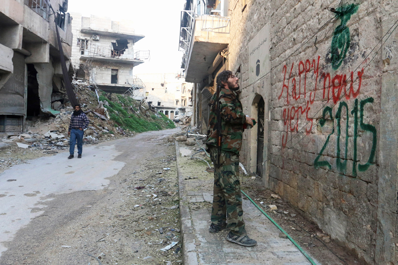 Боец одной из повстанческих группировок в Сирии &ndash; Свободной армии Сирии &ndash;&nbsp;рисует на стене в Алеппо поздравление с Новым годом.