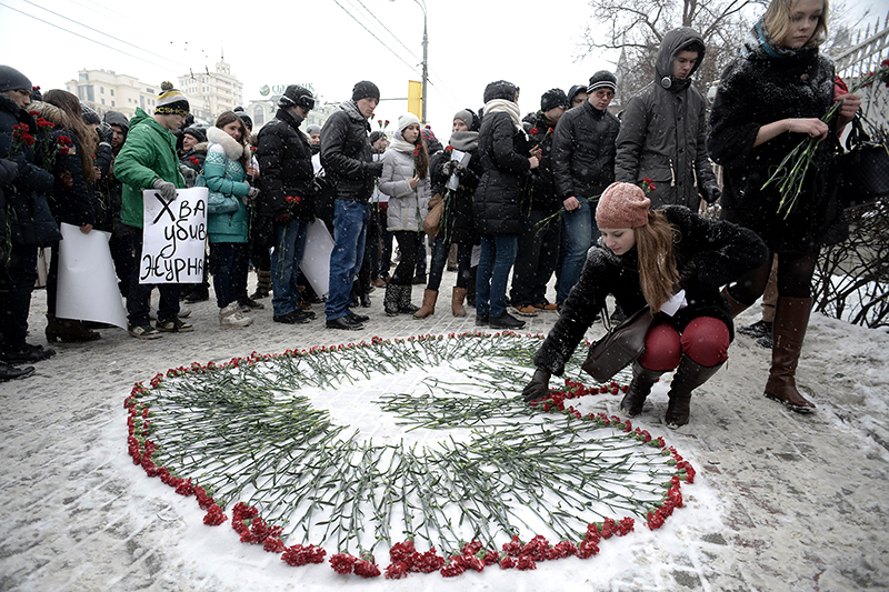 Участники акции солидарности с журналистами Charlie Hebdo создают сердце из цветов у посольства Франции в Москве