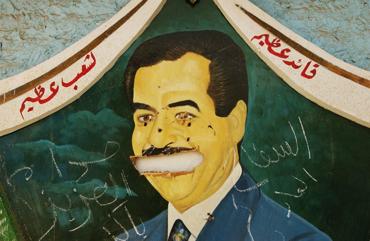 Испорченный портрет Саддама Хусейна на стене зловещей тюрьмы "Абу-Грейб". 