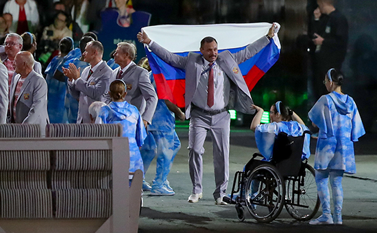 Член белорусской делегации Андрей Фомочкин несет флаг России на&nbsp;церемонии открытия XV Паралимпийских летних&nbsp;игр, 7 сентября 2016 года
