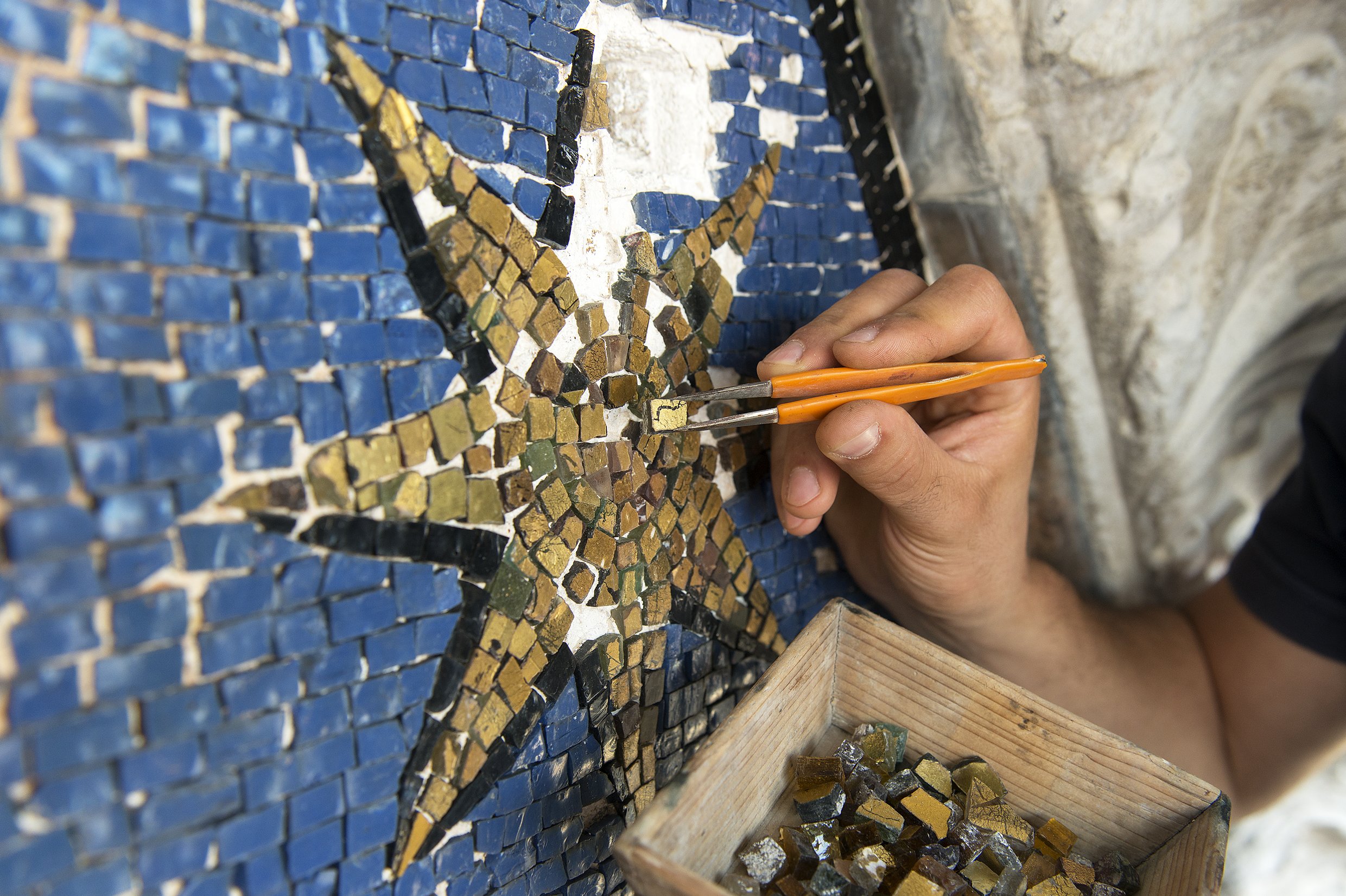 Процесс реставрации синей мозаики с золотыми звездами на фасаде базилики Святого Марка в Венеции