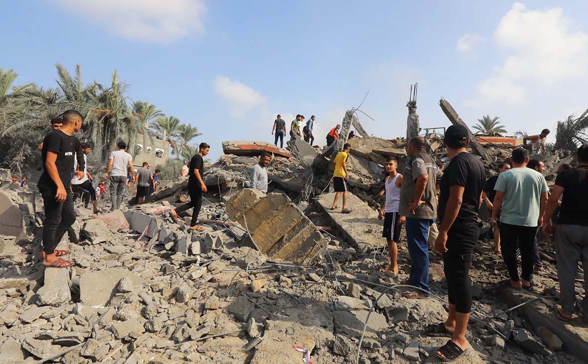 Палестинцы разбирают завалы дома после авиаудара Израиля по городу Дейр-эль-Балах, сектор Газа, 22 октября 2023 года