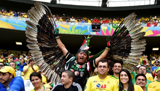 Фанат сборной Мексики в оригинальном костюме с крыльями болеет за свою команду во время матча Бразилия - Мексика на стадионе "Эстадио Пласидо Адералдо Кастело". 17 июня, Форталеза, Бразилия. 