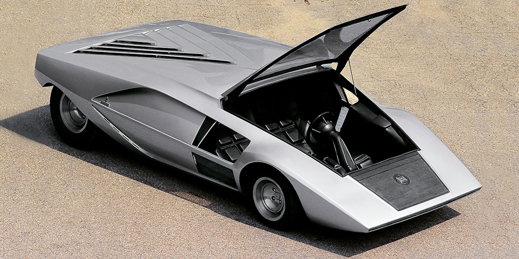 Lanciа Stratos Zero

В 1968 г. студия Bertone показала концепт Alfa Romeo Carabo авторства Марчелло Гандини и ввела моду на клиновидные кузова. Спустя два года она представила еще более необычный концепт Lancia Stratos Zero высотой всего 84 сантиметра. Пассажиры попадали внутрь через подъемное лобовое стекло, а треугольный капот напоминал парус. Stratos Zero позже попадет в музыкальный фильм &laquo;Лунная походка&raquo; Майкла Джексона.
