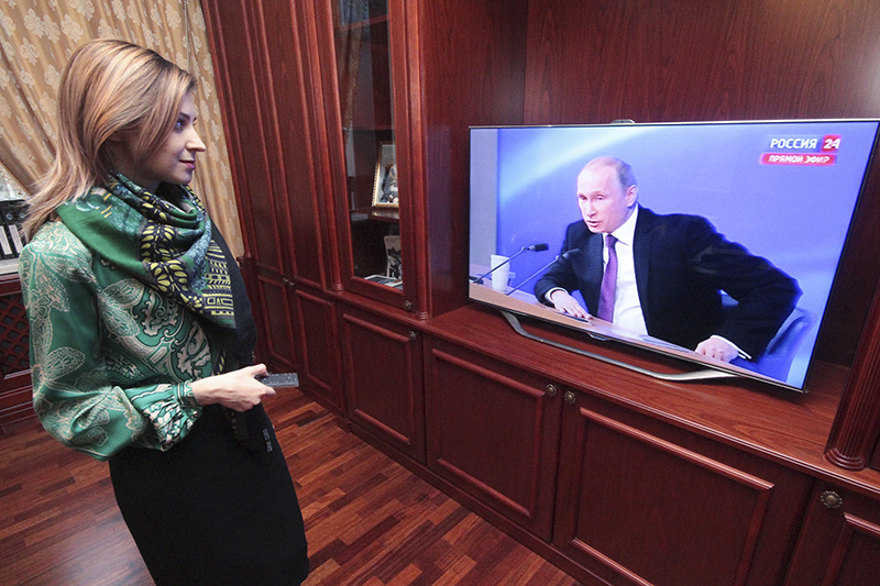 Прокурор Крыма Наталья Поклонская смотрит трансляцию пресс-конференции в рабочем кабинете.