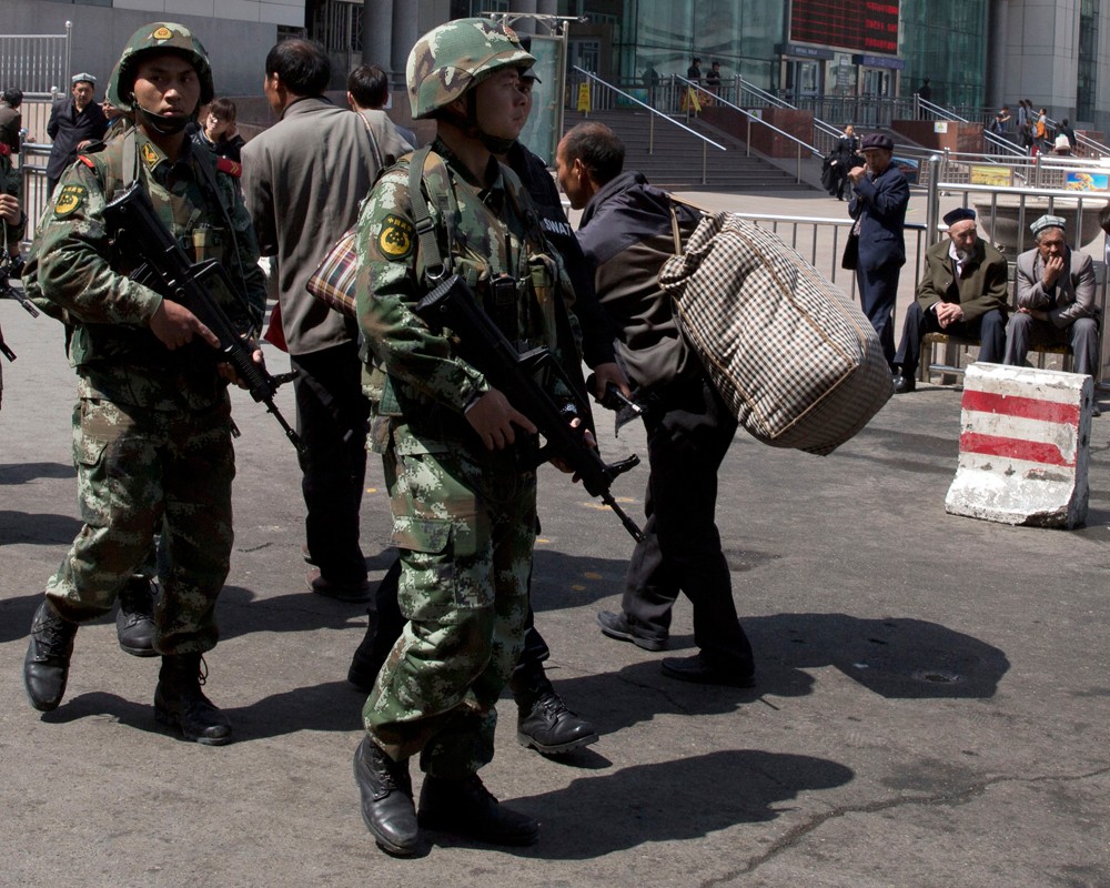 Китайские военизированные полицейские патрулируют территорию возле вокзала