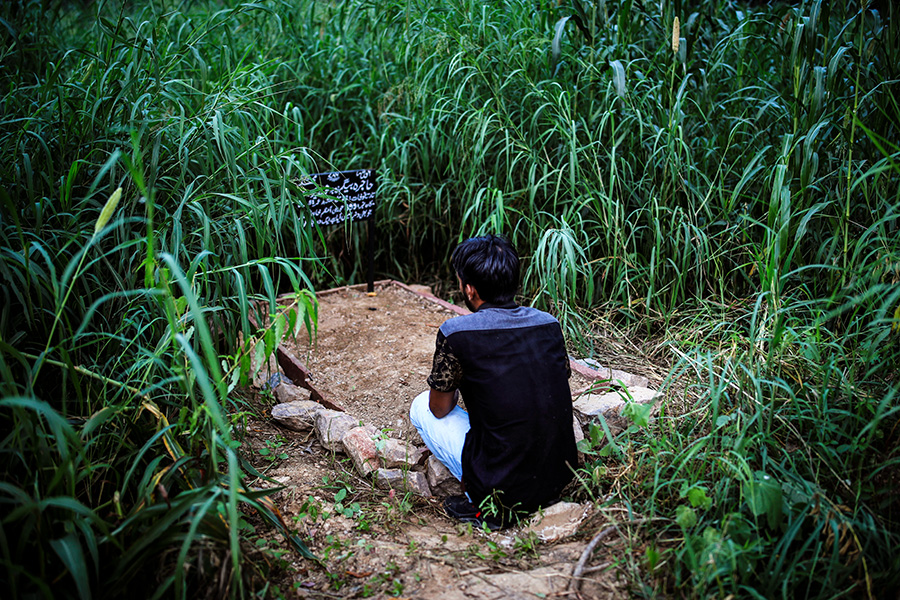 Мужчина на кладбище в Нью-Дели у могилы матери, умершей от коронавируса.