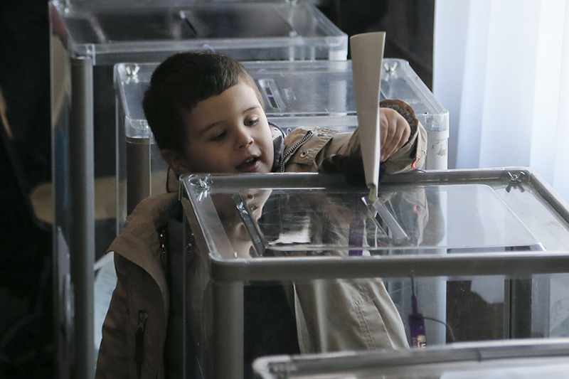 Мальчик на избирательном участке в Киеве бросает бюллетень в урну. В штабе фаворита избирательной гонки, &laquo;Блоке Петра Порошенко&raquo;, рассчитывают, что явка составит около 56-59% избирателей.&nbsp;