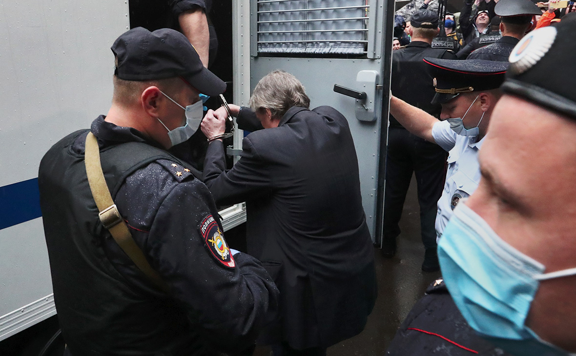 Михаил Ефремов в сопровождении конвоя заходит в полицейский автозак у здания Пресненского суда