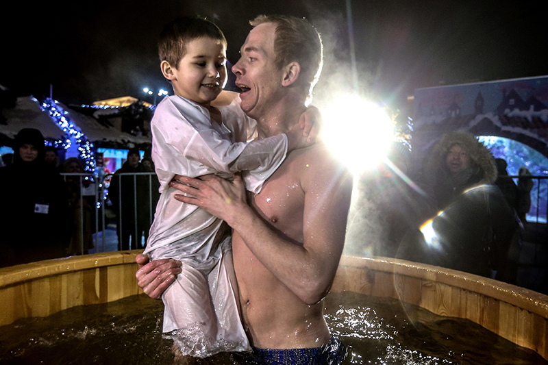 Мужчина с ребенком на крещенских купаниях 19 января 2016 года