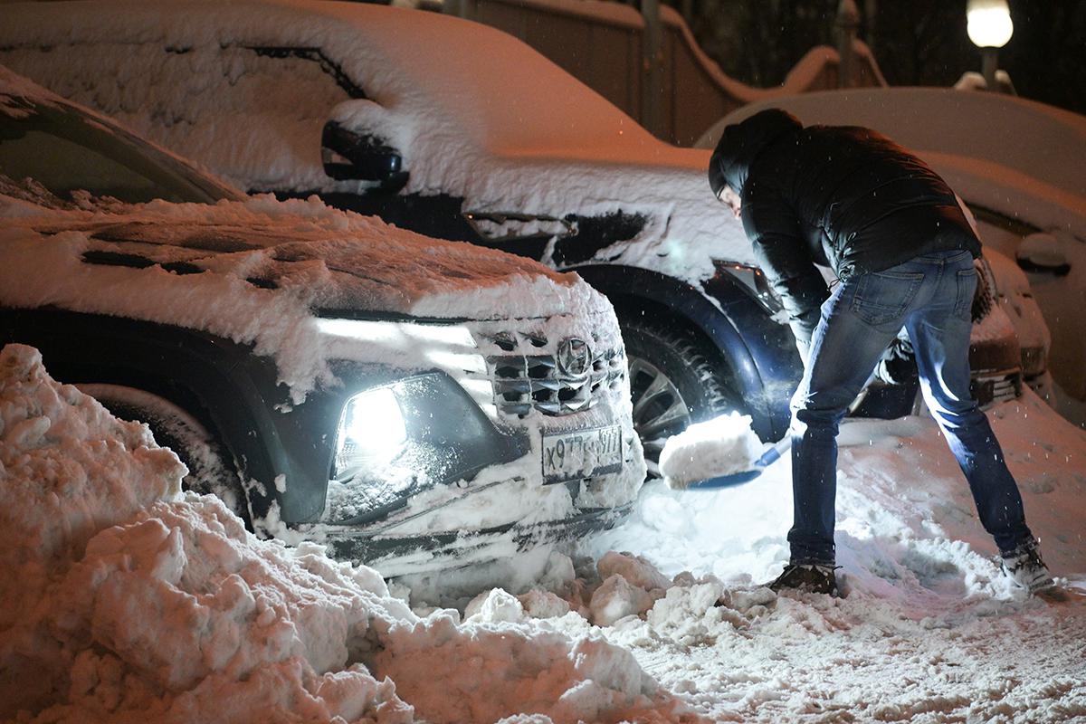 Мужчина расчищает автомобиль от снега в Москве, 12 января 2026 года