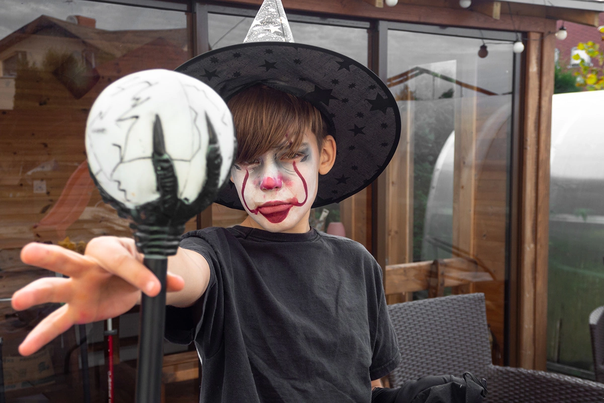 Чтобы грим клоуна выглядел по-хэллоуински зловеще, используйте красные, белые и черные краски аквагрима