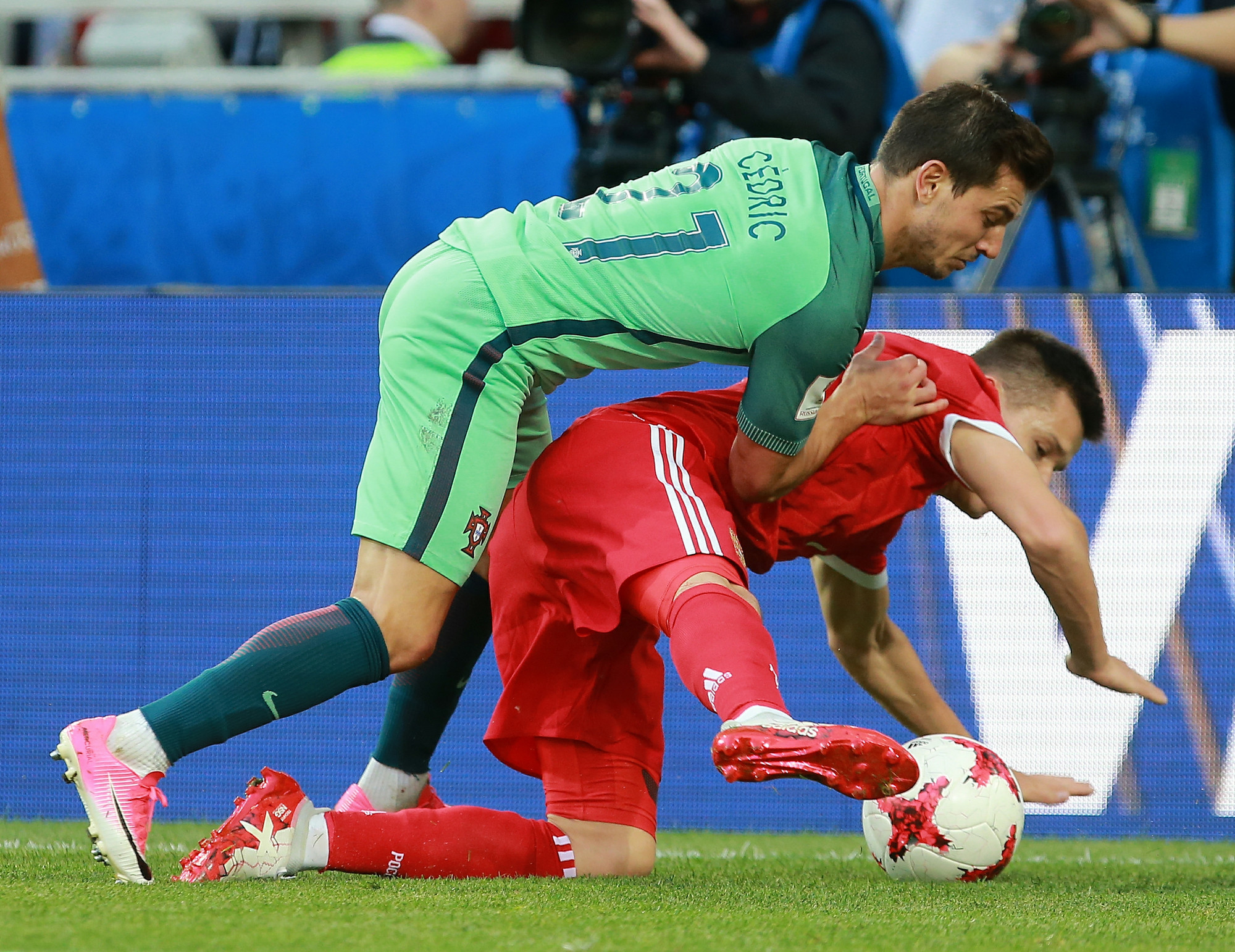 Португальский защитник Седрик (слева) атакует форварда сборной России Дмитрия Полоза
