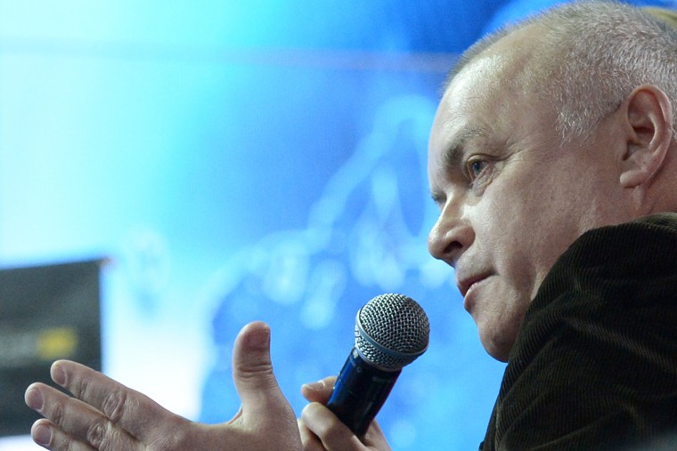 Телеведущий Дмитрий Киселев объясняет ситуацию "на пальцах". Он изобразил руками кольцо, которое его душит. По его словам, это НАТО - "раковая опухоль"