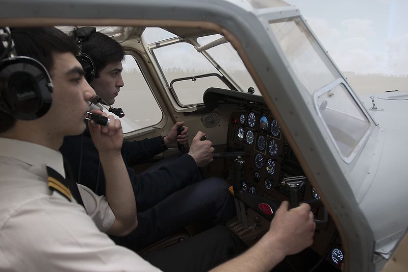 Студенты университета гражданской авиации в тренажере кабины самолета