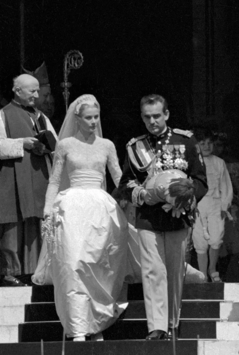 Подвенечное платье Грейс по дизайну оскароносного художника по костюмам Хелен Роуз (тоже подарок от MGM) до сих пор считают эталоном свадебного наряда. 30 портних, шесть недель работы, более 20 м шелковой тафты и 90 м чистого шелка, а еще старинное бельгийское кружево и тысячи жемчужин, пришитых вручную, &mdash; в 1956-м платье обошлось в $65,2 тыс.