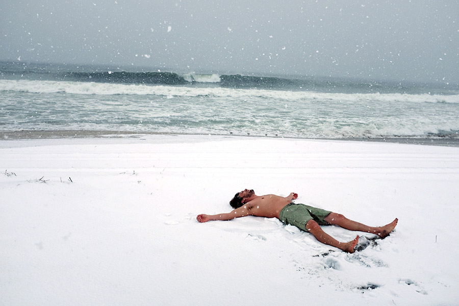 Мужчина на заснеженном пляже Рокуэй-Бич в Нью-Йорке