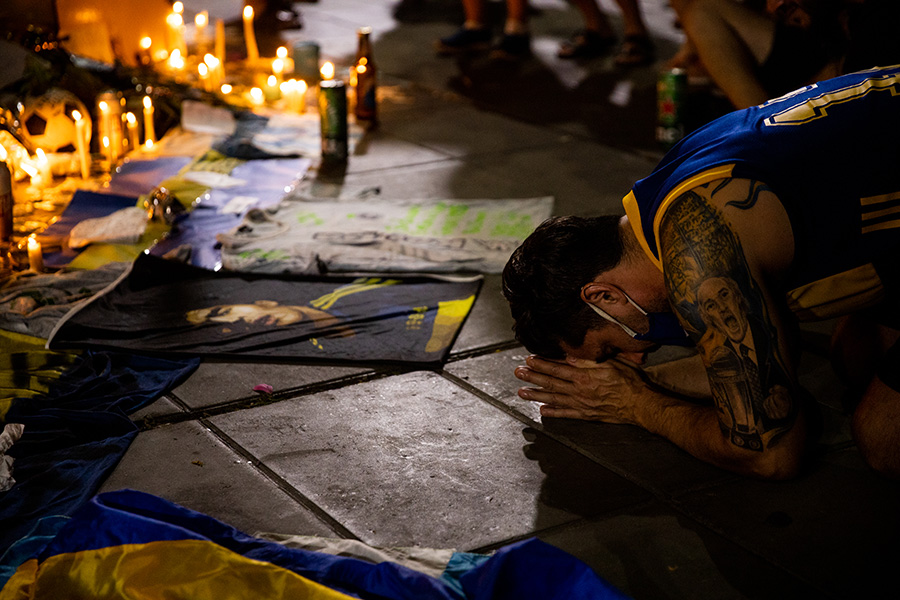 Аргентинский болельщик на коленях скорбит в связи со смертью Марадоны. Один из лучших футболистов в истории умер накануне в больнице Буэнос-Айреса
