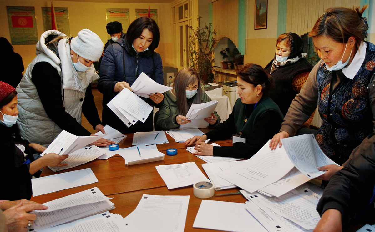 Сотрудники избирательной комиссии во время подсчёта голосов на одном из избирательных участков в Бишкеке после окончания голосования на досрочных выборах президента Кыргызской Республики и референдуме по вопросу формы правления