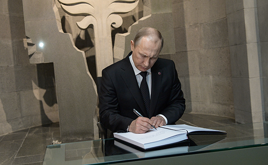 Президент России Владимир Путин расписывается в книге почетных гостей во время посещения мемориального комплекса «Цицернакаберд»
