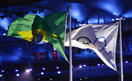Олимпийский и бразильский флаги развеваются на церемонии закрытия&nbsp;летних Олимпийских игр в Рио-де-Жанейро


