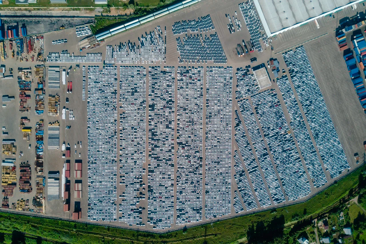 Эта стоянка выглядит компактнее предыдущей, но в реальности она тоже очень большая. Длина каждого из основных рядов по центру&nbsp;&mdash; около 100 автомобилей, ширина&nbsp;&mdash; 9 или 10. Таким образом, вы смотрите примерно на 6,5-7 тысяч новых машин.