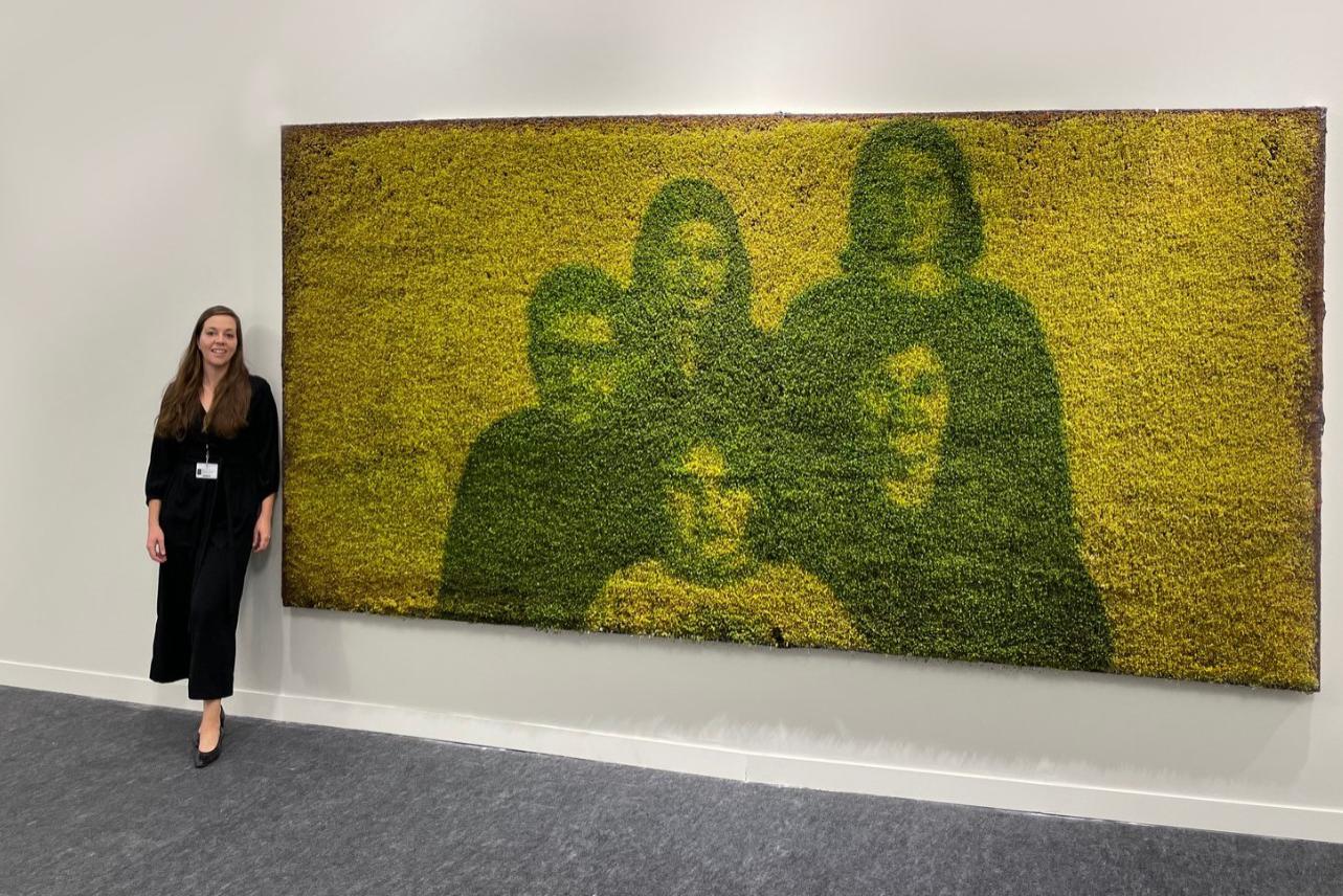 Альмудена Ромеро рядом с портретом семьи на выставке &laquo;Изменение пигмента&raquo; в Париже в 2021 году