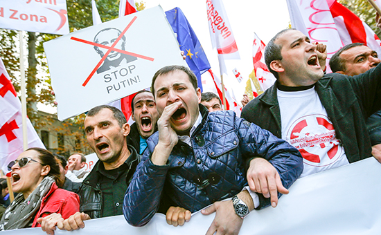 Люди кричат ​​лозунги во время митинга оппозиции в знак протеста против политики России в отношении Грузии и Украины в Тбилиси, 15 ноября 2014