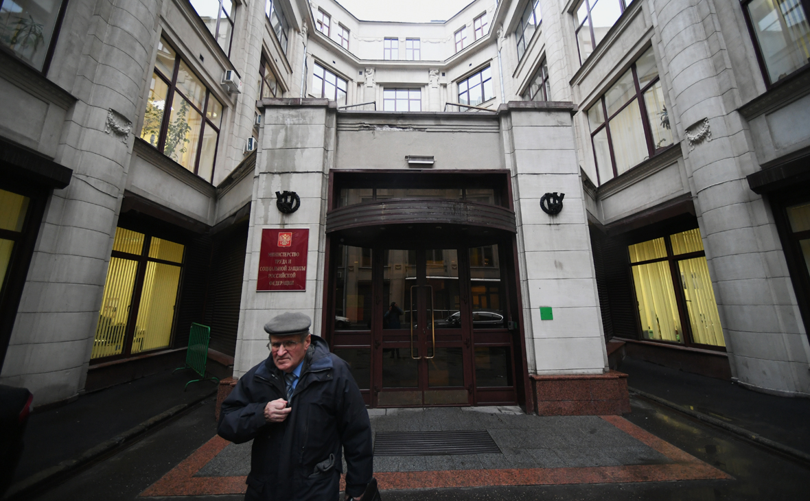 Мужчина выходит из здания Министерства труда и социальной защиты Российской Федерации в Москве