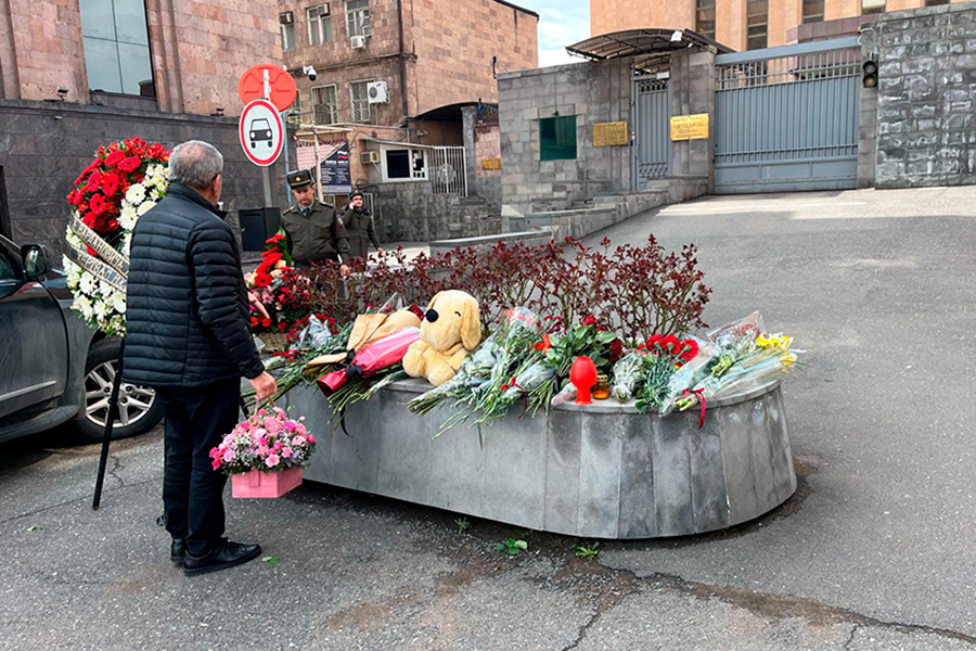 Мужчина возлагает цветы у посольства России в Ереване