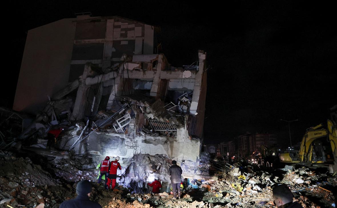 Спасатели работают на месте обрушения здания после землетрясения в Искендеруне