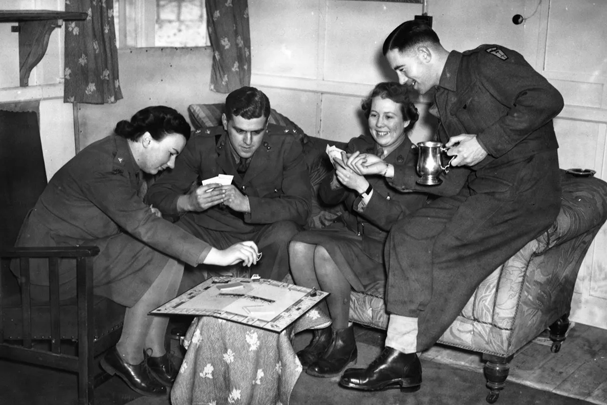 Офицеры британской армии и вспомогательных территориальных служб играют в «Монополию» в общей офицерской столовой, январь 1942 года