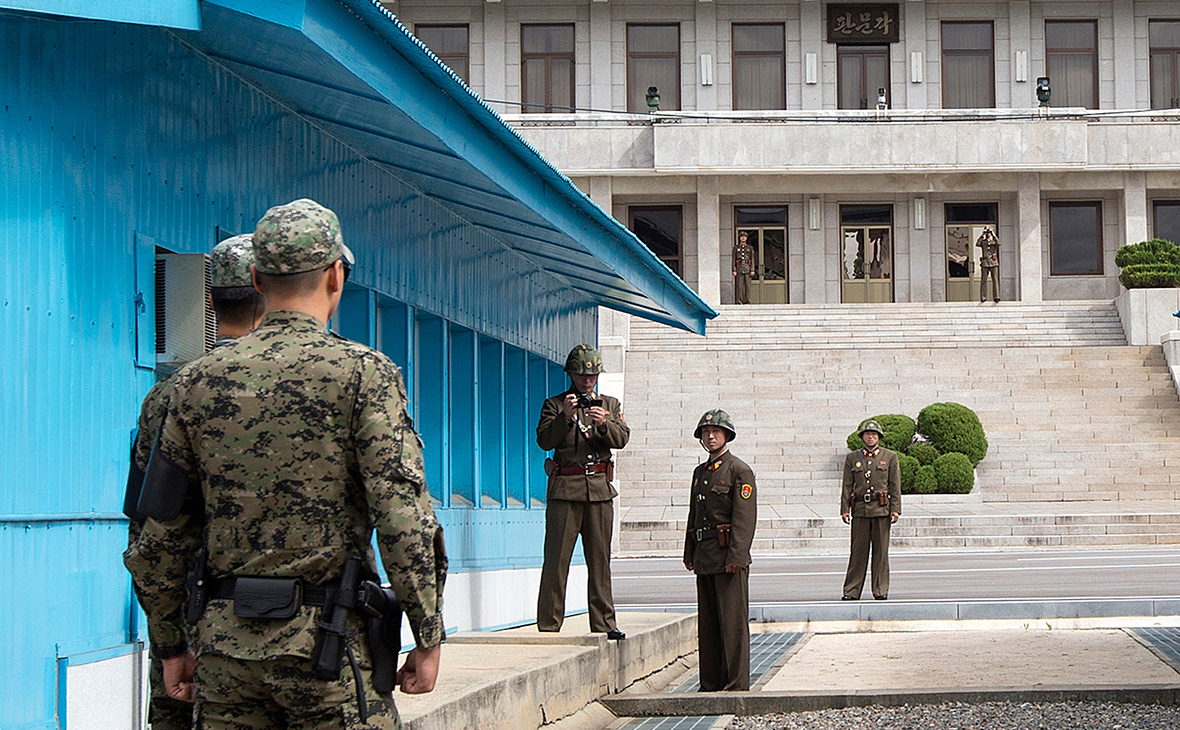 Солдаты Южной Кореи (слева) и солдаты КНДР на границе между государствами&nbsp;в деревне Панмунджом. 30 сентября 2013 года
