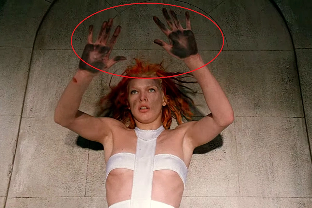 Руки героини заметно испачканы, ладони практически черные, кадр из фильма «Пятый элемент»