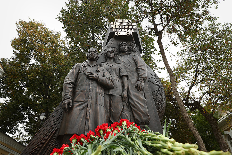 Скульптура изображает медиков в защитных масках, за спиной у них&nbsp;&mdash; земной шар