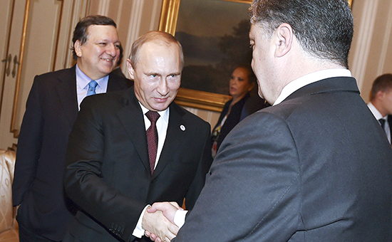Президент России Владимир Путин (в центре) пожимает руку президенту Украины Петру Порошенко на саммите в Милане