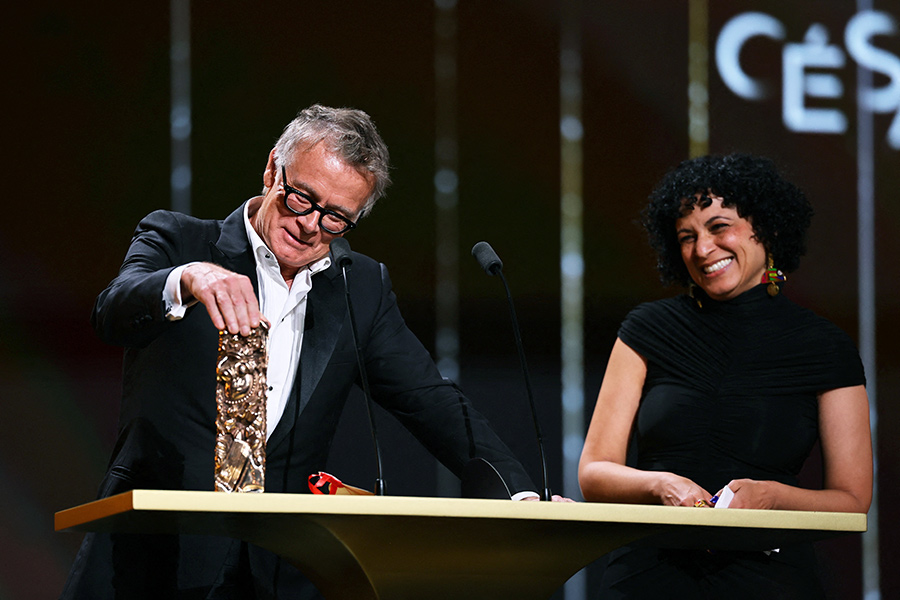 Режиссер Франк Дюбоск и сценаристка Сара Камински произносят речь во время вручения премии за лучший оригинальный сценарий за фильм «Как заработать на убийстве» («Un ours dans le Jura»). Дюбоск получил своего первого «Сезара» спустя 44 года карьеры. «Это невероятно! Мы так рады, что вы оценили нашу искренность», &mdash; заявил он.