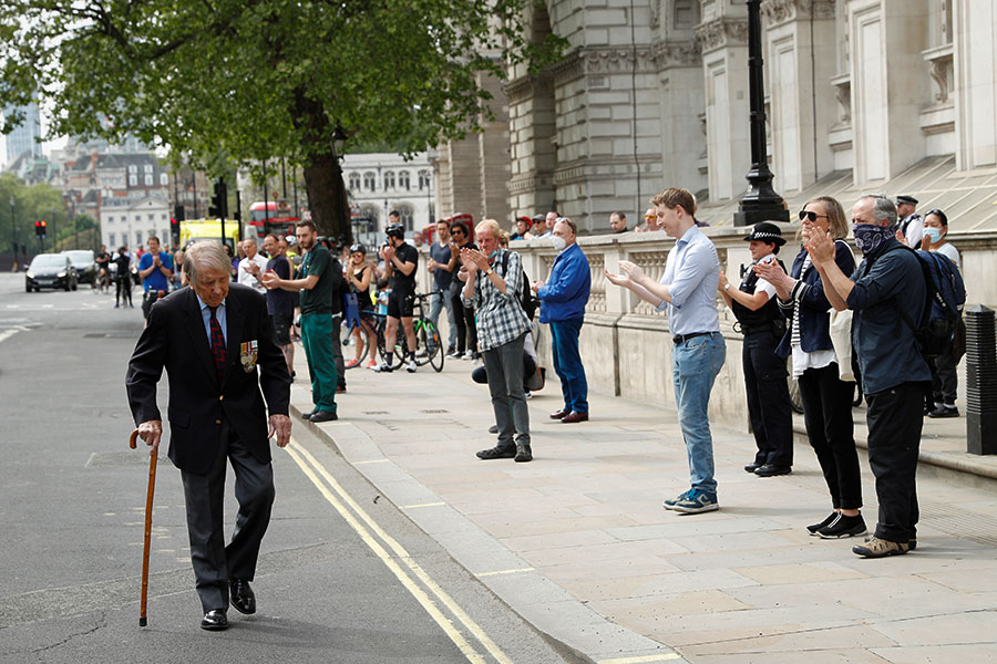 Люди аплодируют ветерану рядом с военным мемориалом в Лондоне, Великобритания
