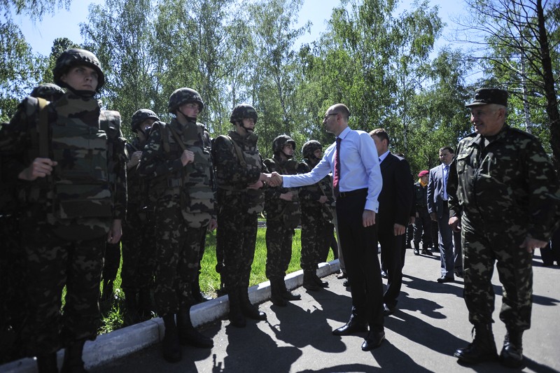 Украинский премьер-министр Арсений Яценюк приветствует солдат на военном полигоне под Киевом. 