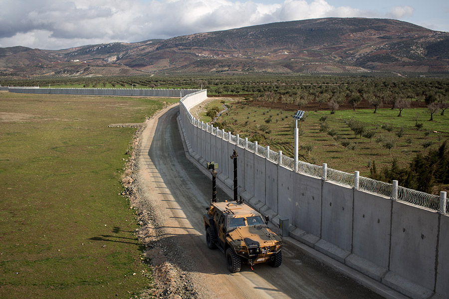 На фото: 2 марта 2017 года. Турецкие солдаты патрулируют пограничную стену с Сирией во время учений

Турция начала строительство стены на границе с Сирией в 2015 году для&nbsp;борьбы с незаконной иммиграцией. Сейчас заграждение представляет собой бетонную стену высотой 3 м и протяженностью более 750&nbsp;км. О завершении строительства турецкие власти объявили в июле 2018 года&nbsp;