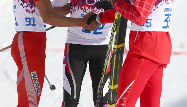 Золотой призер Олимпиады в Сочи швейцарский лыжник Дарио Колонья (справа) остался на финише, чтобы поприветствовать перуанца Роберто Карселена (в центре) и лыжника из Непала Дашери Шерпа (слева). 
