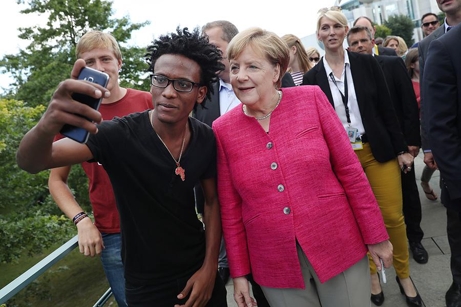 Ангела Меркель делает селфи с беженцем из Эритреи, 2017 год