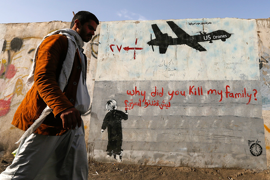 На следующий день после&nbsp;захвата хуситами Амрана в&nbsp;июле 2014 года ВВС Йемена нанесли авиаудары по&nbsp;зданиям правительства. С этого времени в&nbsp;стране продолжается вооруженный конфликт между&nbsp;правительственными войсками и&nbsp;повстанцами-хуситами.

На фото: мужчина проходит мимо&nbsp;граффити с&nbsp;надписью &laquo;Почему вы убили мою семью?&raquo; и&nbsp;изображением американского дрона. Сана, ноябрь 2014
