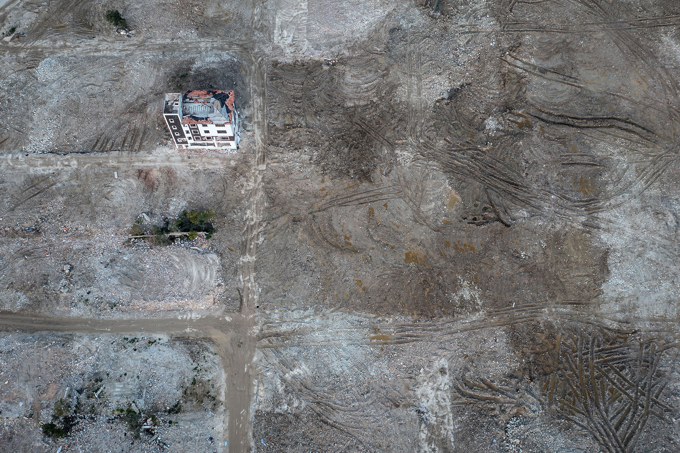 Вид с воздуха на поврежденный землетрясением жилой дом в Хатае, 2 февраля 2024 года. Вокруг&nbsp;&mdash; расчищенный от завалов участок: год назад на этом месте был жилой квартал.