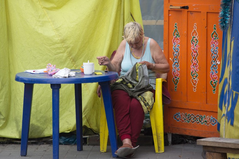 Женщина штопает одежду в лагере активистов Евромайдана. Быт самообороны был налажен еще в декабре 2013г. Система питания Майдана ежедневно обеспечивала до 50 тыс. человек, а постоянный подвоз дров позволял им оставаться на улицах даже в зимние ночи. Сейчас необходимость в таких подвигах отпала. 
