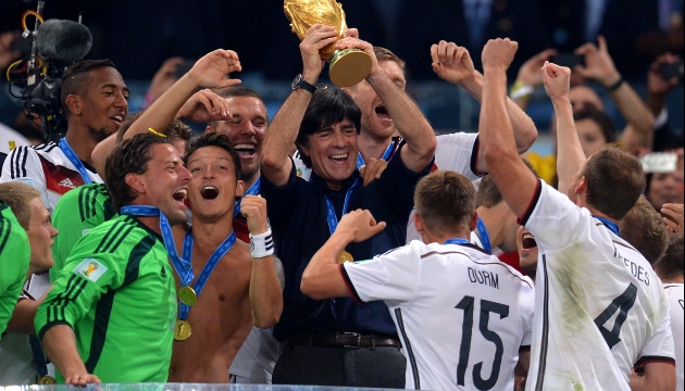 Главный тренер сборной Германии Йоахим Лев держит в руках кубок мира.