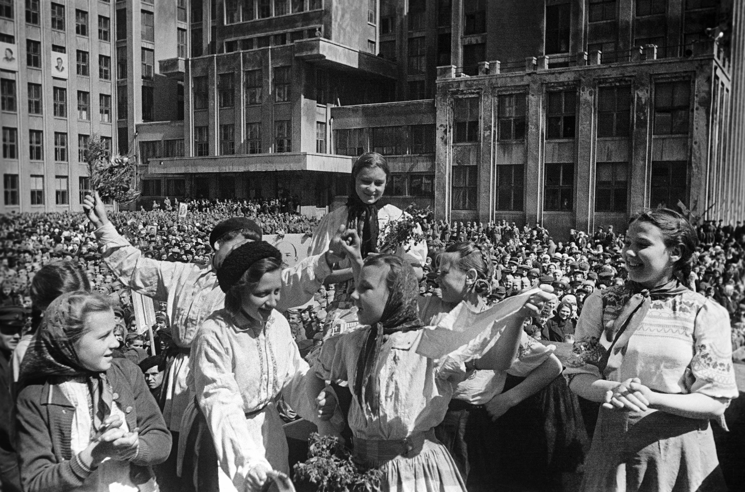 На фото: Минск, 9 мая 1945 года
Минчане также узнали о победе в ночь на 9 мая. Они собрались в центре города, пели, играли на гармошках, танцевали, дарили друг другу цветы.
Утром 9 мая они начали украшать город — развешивали флаги и транспаранты, в окна выставили портреты партийных деятелей и военачальников.