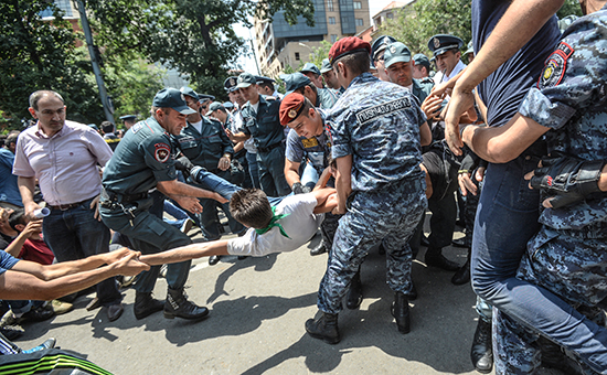 Сотрудники полиции задерживают участника акции протеста против повышения тарифов на электроэнергию в Ереване